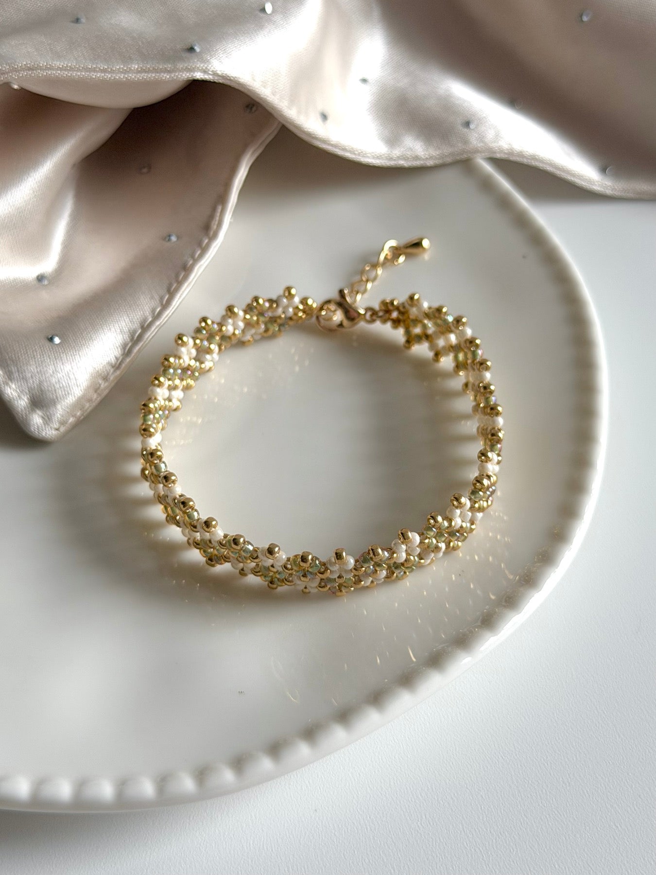 Circular detail view of a handwoven ivory seed bead bracelet