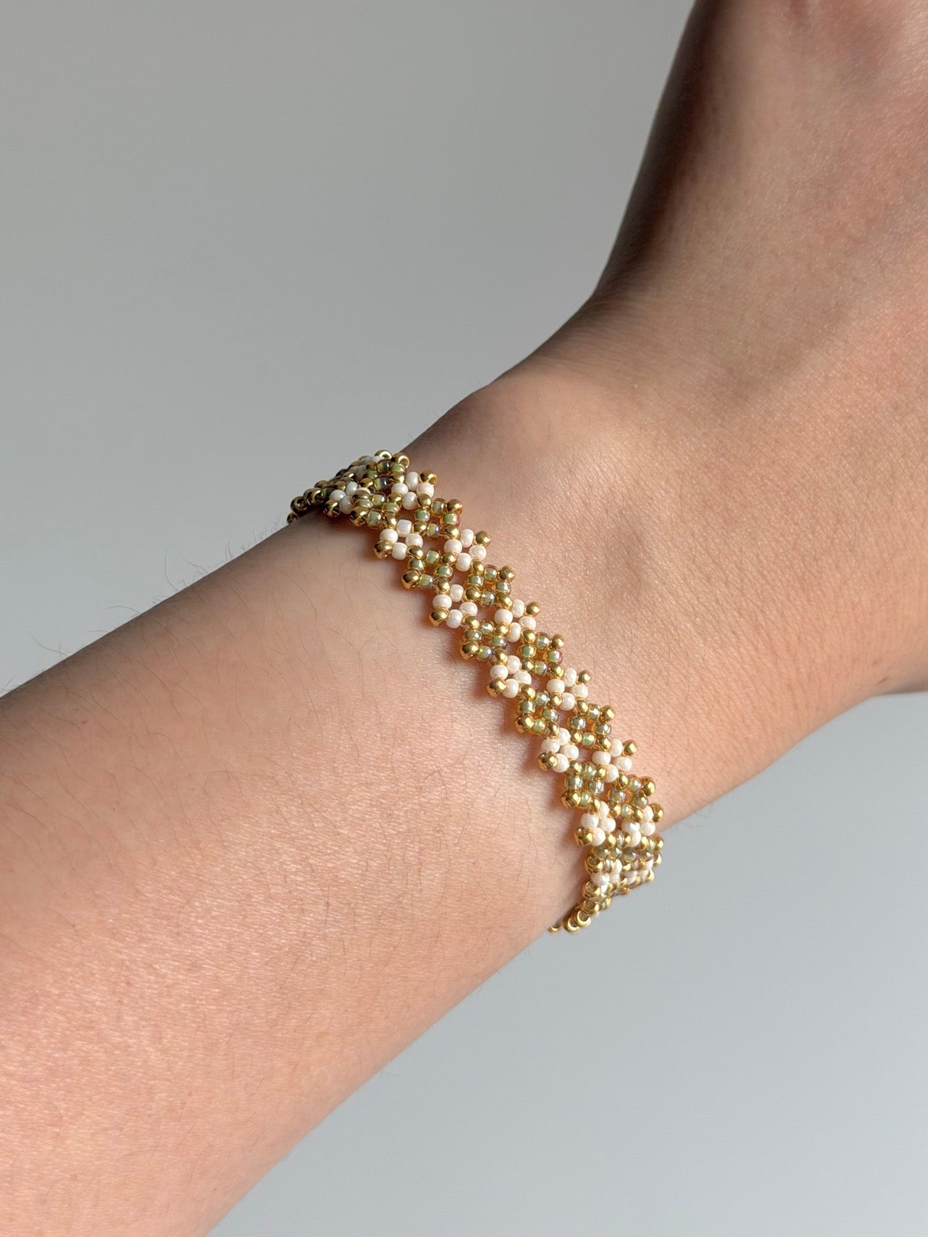 Handwoven ivory seed bead bracelet shown on the wrist